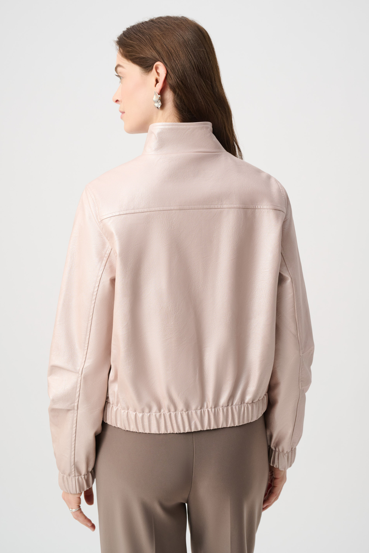 Woman wearing a beige jacket on a light gray background