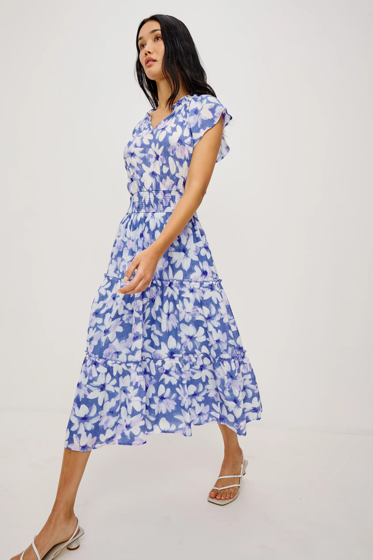 Woman wearing a blue floral dress on a white background