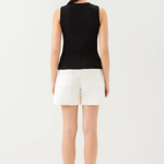 Woman wearing a black sleeveless top and white shorts on a white background