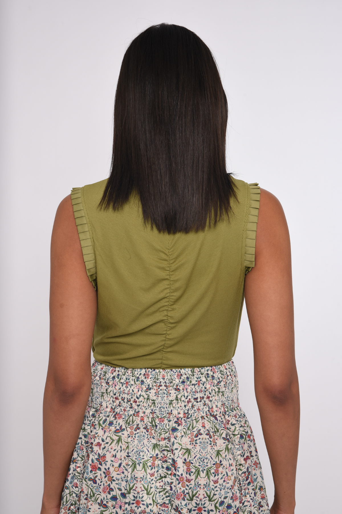 Model wearing an olive green sleeveless knit tank.