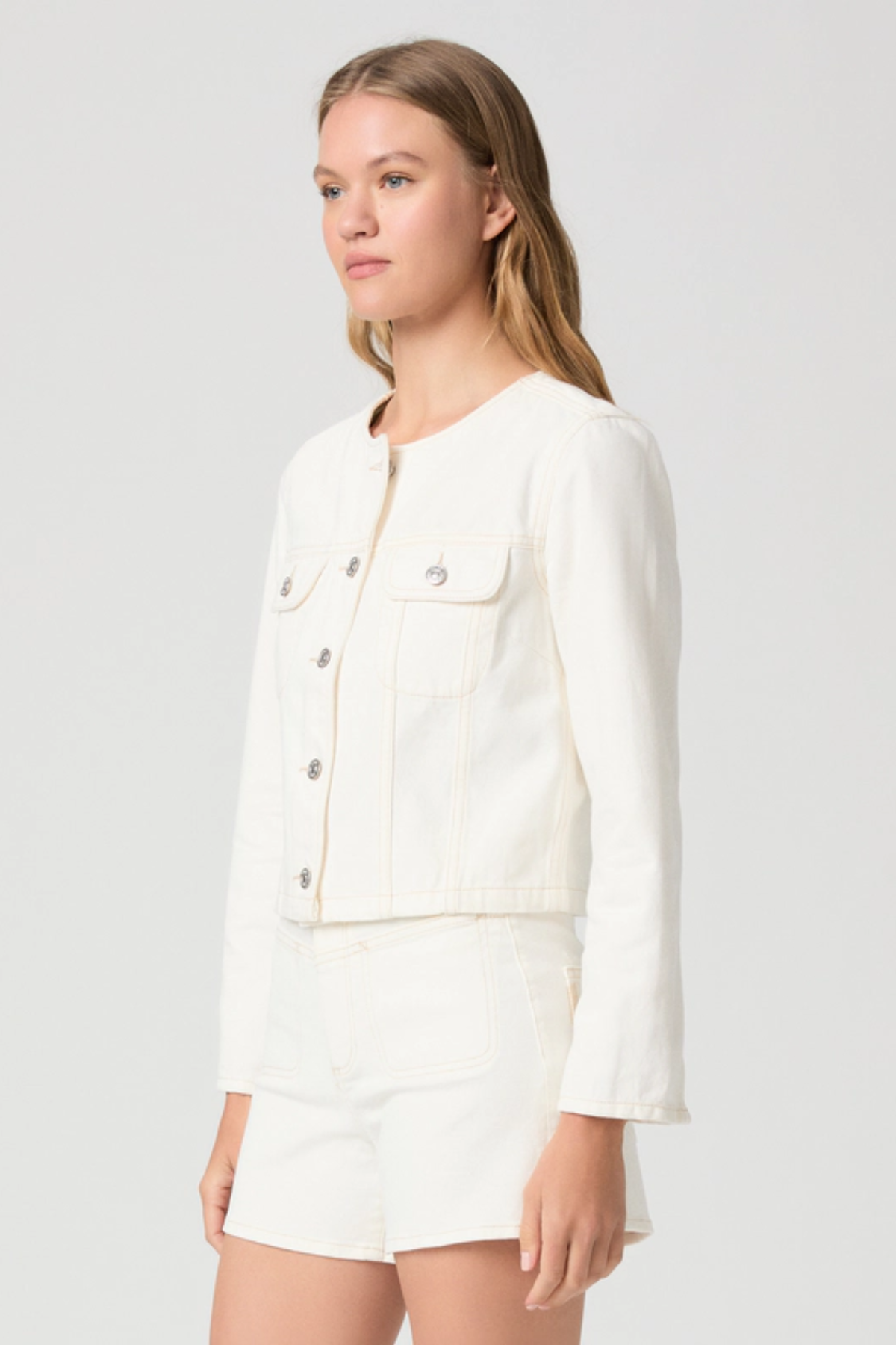 Woman wearing a white jacket on a plain background