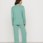 Person wearing a teal pajama set on a plain background