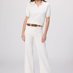 Woman wearing a white blouse and pants with a brown belt on a white background