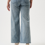 Light blue jeans worn by a person on a white background