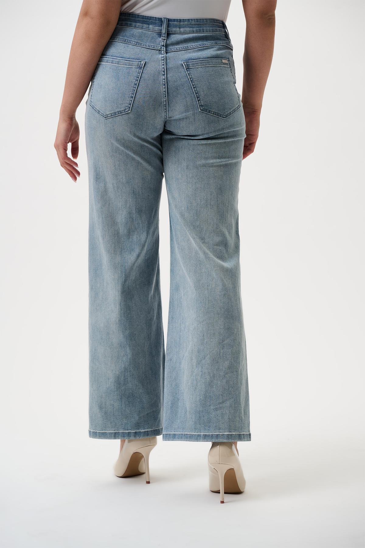 Light blue jeans worn by a person on a white background
