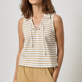 Woman wearing a striped sleeveless top and beige pants against a plain background