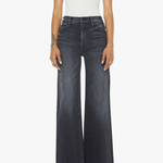 Person wearing black flared jeans and a white t-shirt on a white background