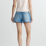 Person wearing a white t-shirt and blue denim shorts on a plain background