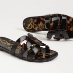 Tortoiseshell sandals with brand name on a light gray background