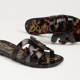 Tortoiseshell sandals with brand name on a light gray background