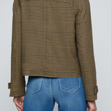 Model wearing a printed trench jacket with jeans on an off white background.