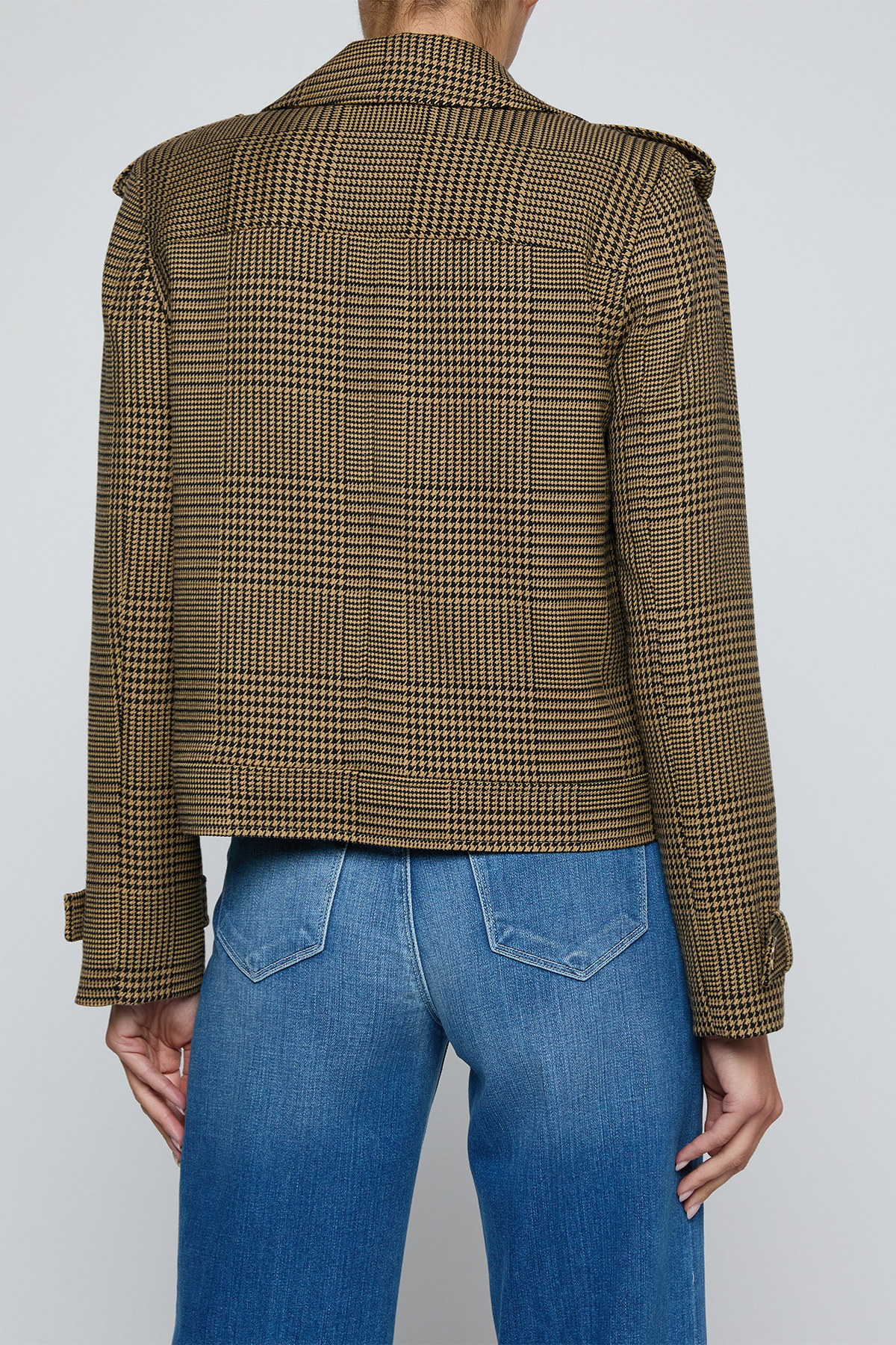 Model wearing a printed trench jacket with jeans on an off white background.
