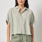 Woman wearing a striped shirt and green shorts against a plain background