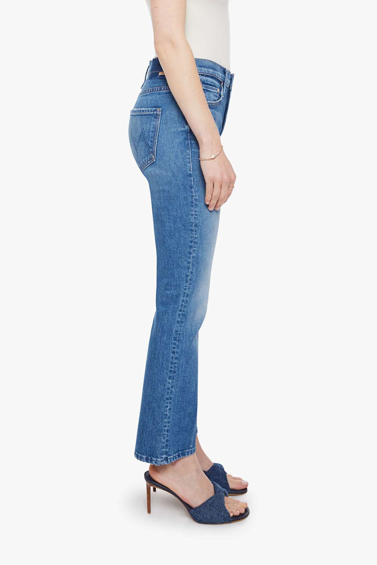 Woman wearing mid-wash cropped flare jeans with a slim upper fit and subtle kick-flare hem.
