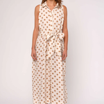 Woman wearing a sleeveless dress with a polka dot pattern on a white background