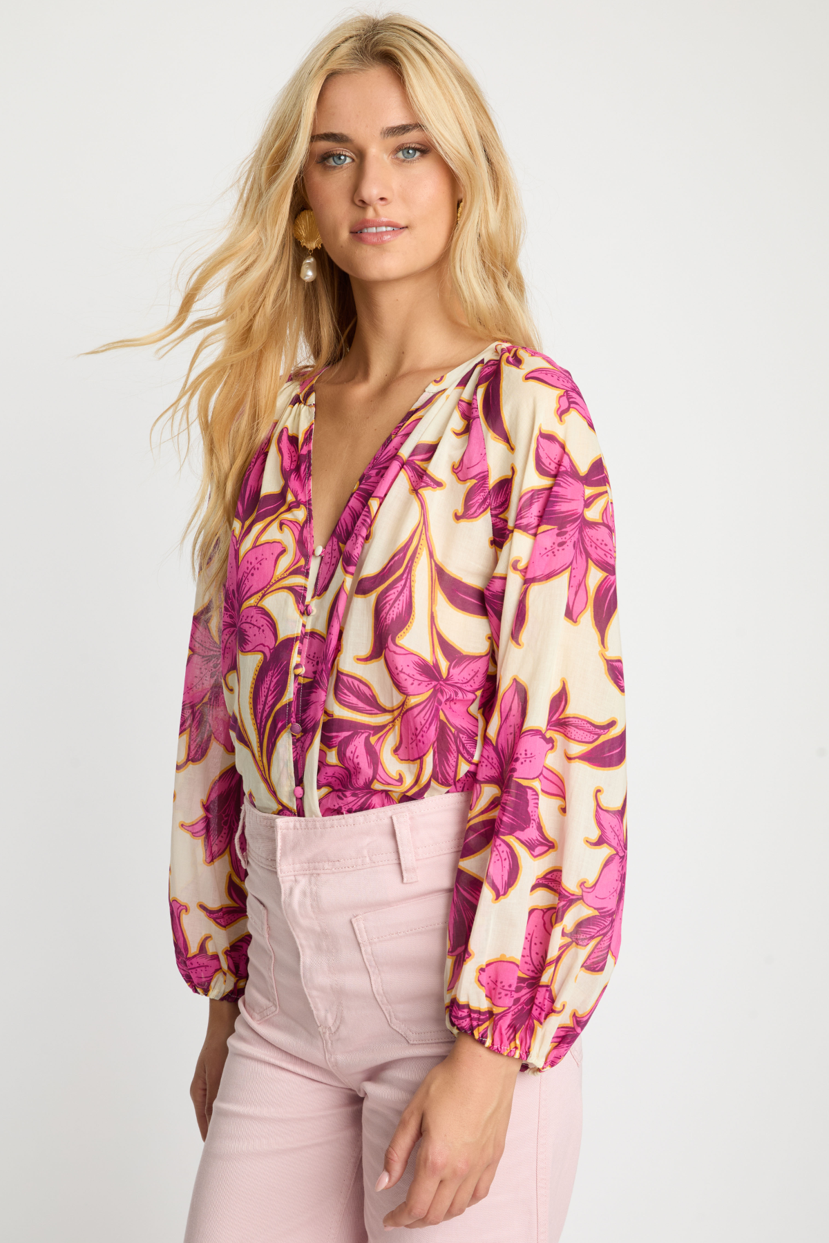 side view of woman in pink printed blouse on white background 