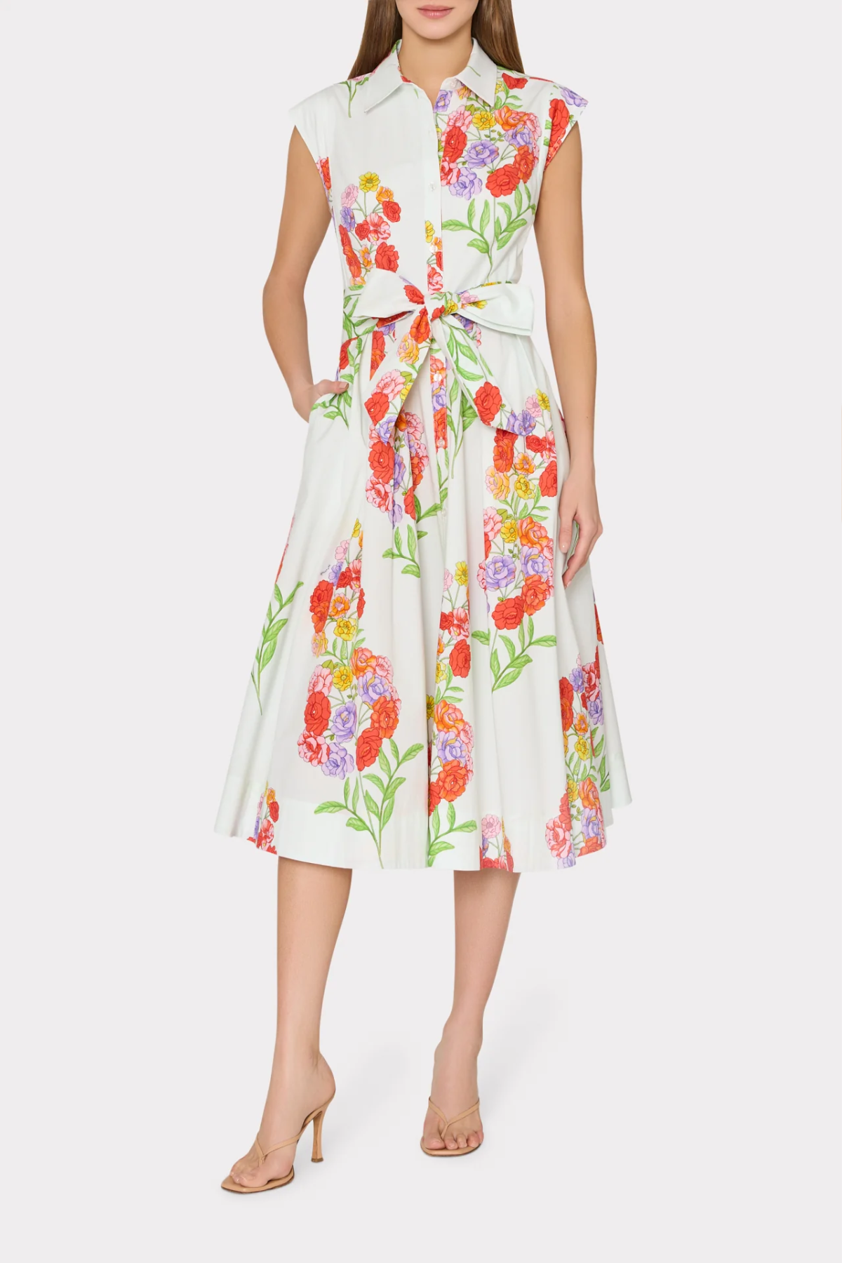 Woman wearing a sleeveless floral dress on a white background