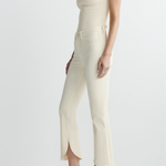 side view of woman in cream outfit on white background 