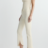 side view of woman in cream outfit on white background 