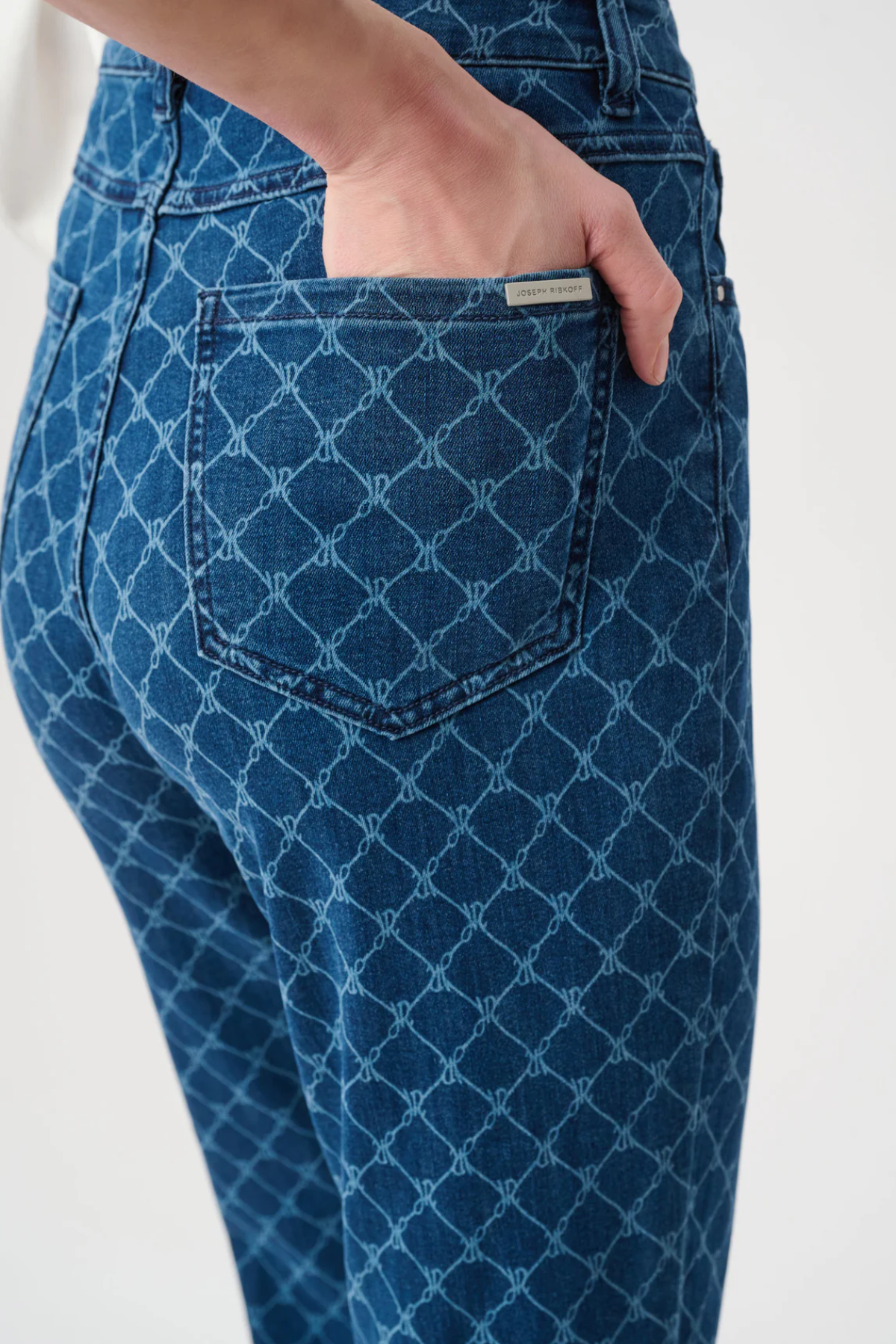 Blue patterned jeans with a visible brand tag on a white background