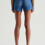 Person wearing blue denim shorts on a white background