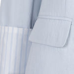 Light blue suit jacket with striped shirt collar on a white background