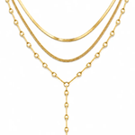 A gold multi-layer necklace featuring three distinct chain styles: a flat curb chain, a textured rope chain, and a beaded chain with a Y-shaped drop, displayed on a clean white background.