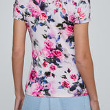Person wearing a floral t-shirt with pink roses on a plain background