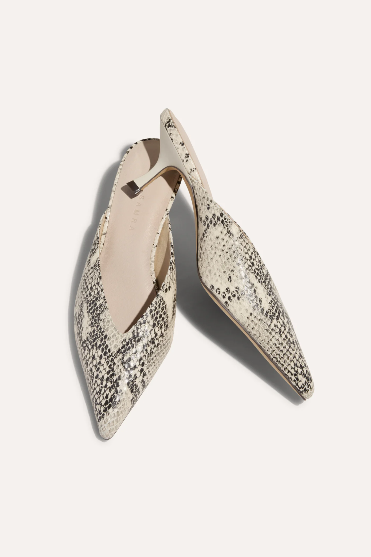 snakeskin kitten heels on white background 