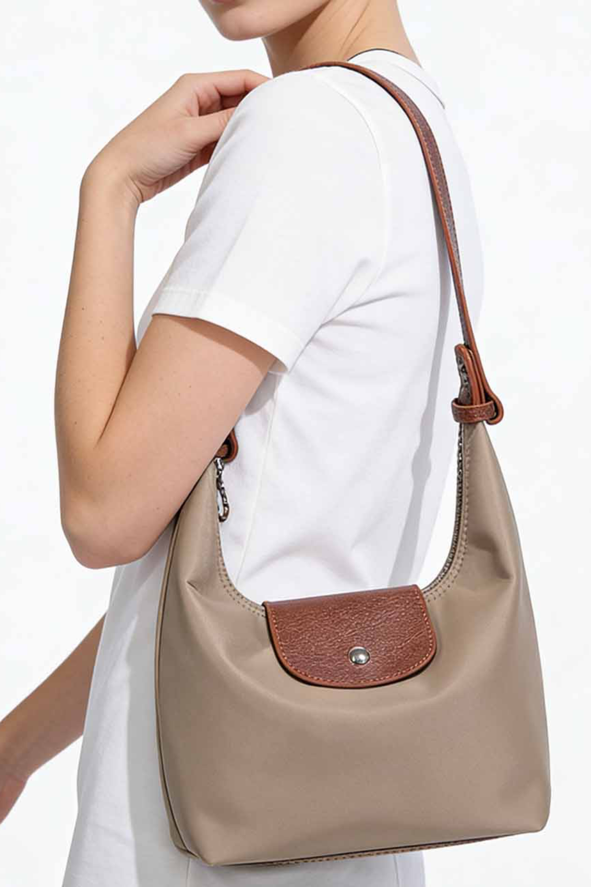 Person wearing a beige handbag with brown accents on a white background