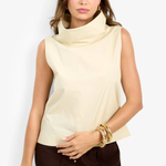 Woman wearing a beige sleeveless top and brown pants on a white background