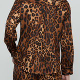 A person shown from the back wearing a leopard-print long-sleeve shirt and matching pants against a light gray studio background.