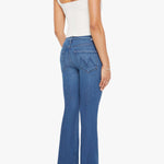 Woman wearing mid-wash flared jeans with a slim fit through the hip and gentle flare at the hem.