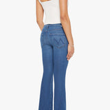 Woman wearing mid-wash flared jeans with a slim fit through the hip and gentle flare at the hem.