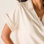 Woman wearing a beige blouse with a neutral background