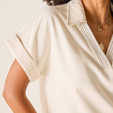 Woman wearing a beige blouse with a neutral background