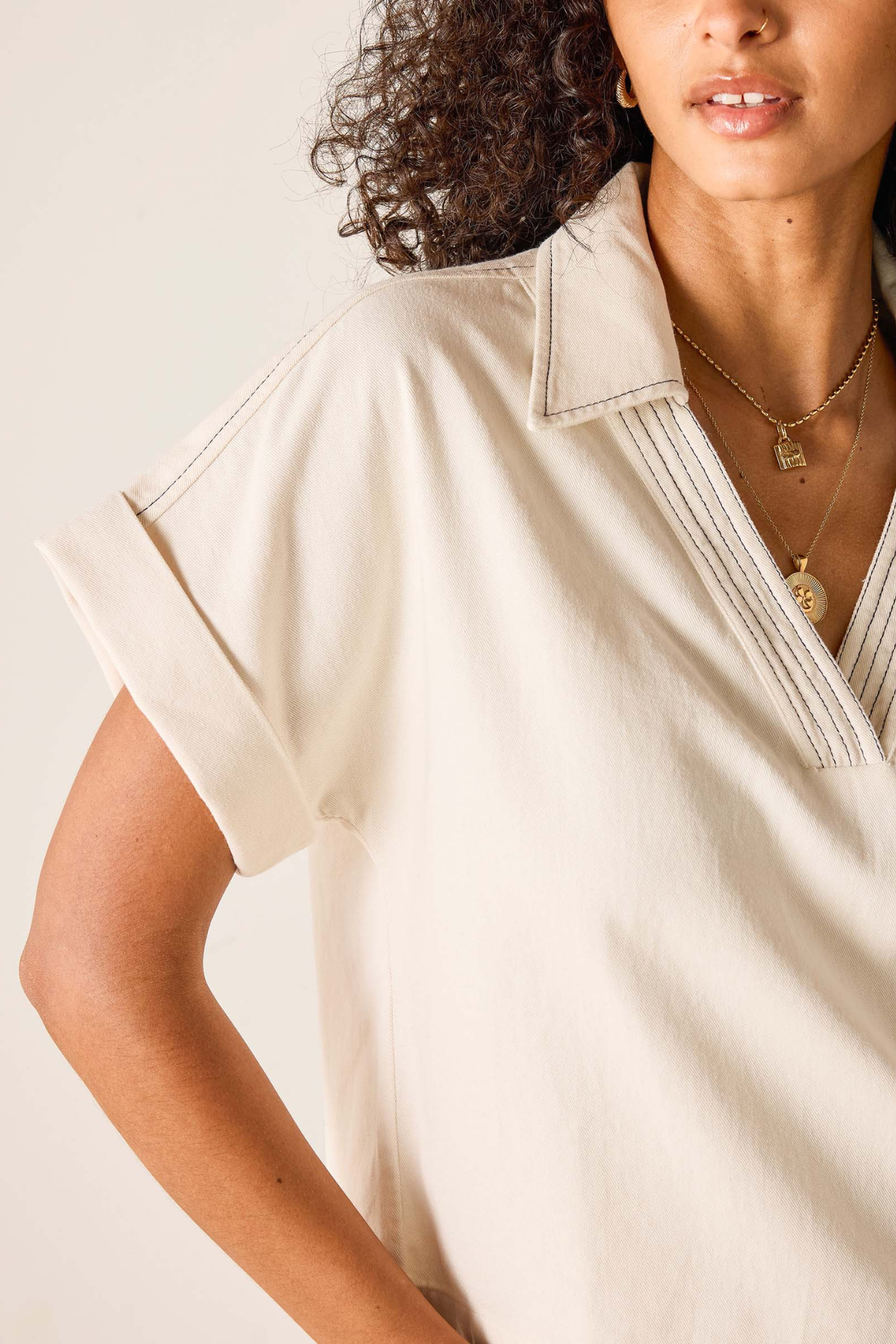 Woman wearing a beige blouse with a neutral background