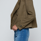 Model wearing a printed trench jacket with jeans on an off white background.