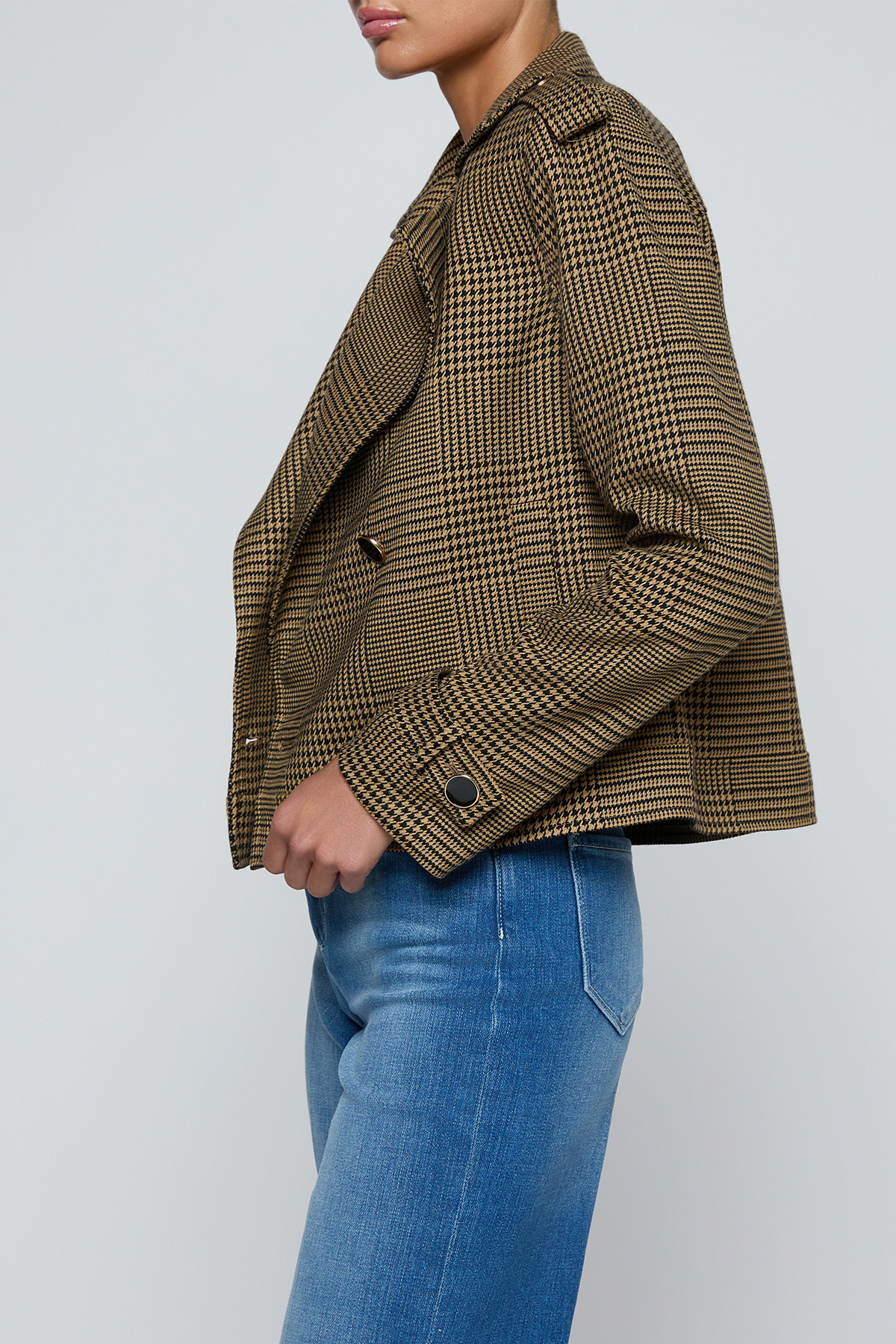 Model wearing a printed trench jacket with jeans on an off white background.