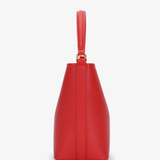 side view of red handbag on white background