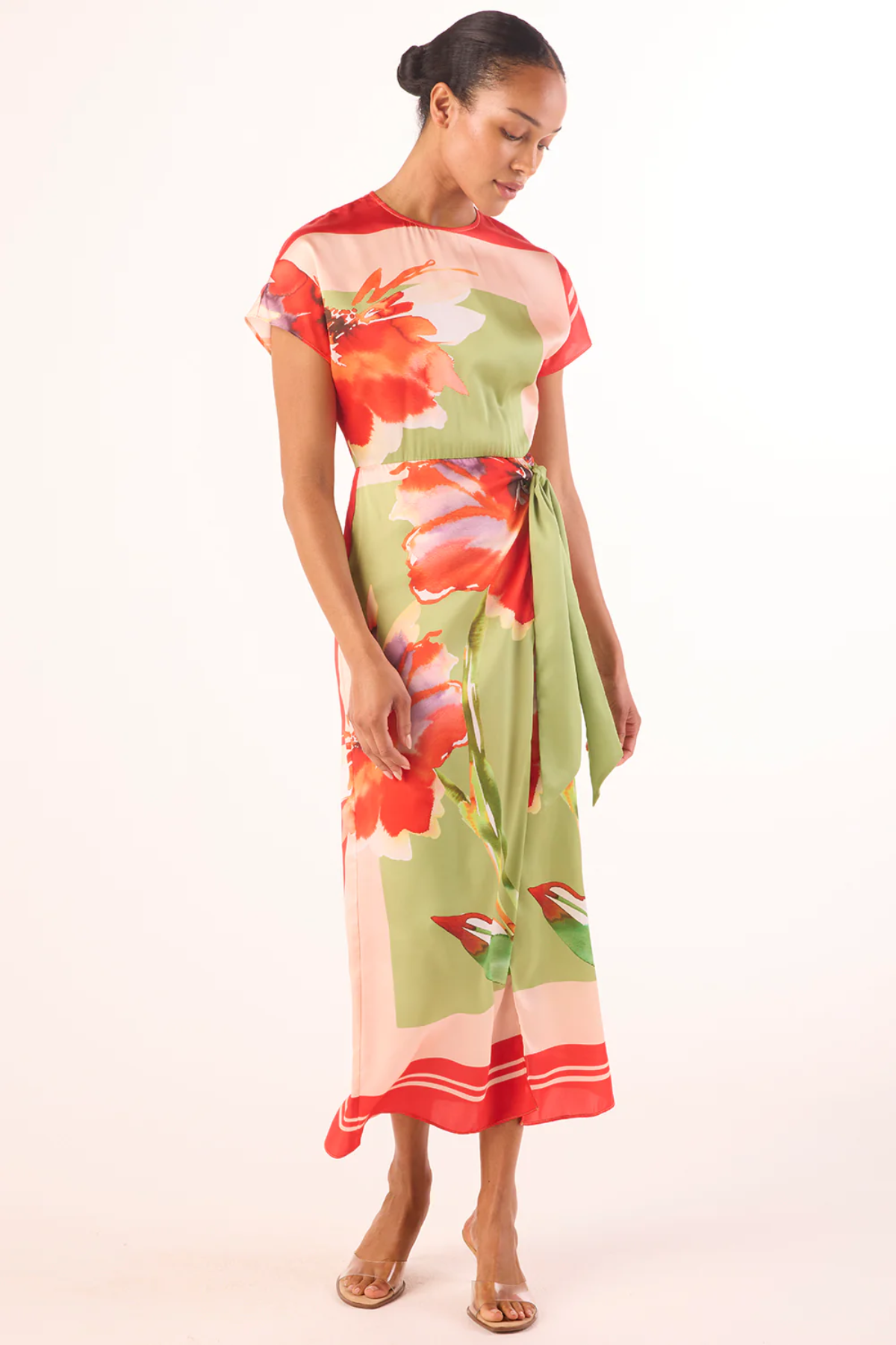 Woman wearing a colorful floral dress on a white background