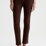 A model wearing dark brown skinny jeans and black pointed-toe heels, shown from the waist down against a plain white studio background.