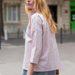 Woman wearing a striped shirt and jeans on a street with a blurred background