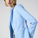 Woman wearing a light blue sweater against a plain background