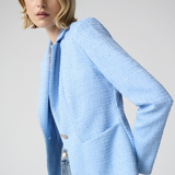 Woman wearing a light blue sweater against a plain background