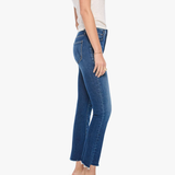 A side-profile view of a model wearing blue cropped ankle jeans, a light beige sleeveless top, and gray high-heeled sandals against a plain white studio background.