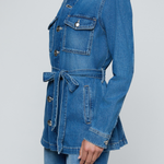 Model wearing a blue denim safari jacket with utility pockets and a button-front design.