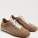 Pair of brown sneakers with white laces on a light gray background
