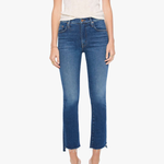A model wearing a cream-colored short-sleeve top and blue cropped flare jeans with side slits, paired with silver heeled sandals, against a plain white background.