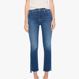 A model wearing a cream-colored short-sleeve top and blue cropped flare jeans with side slits, paired with silver heeled sandals, against a plain white background.